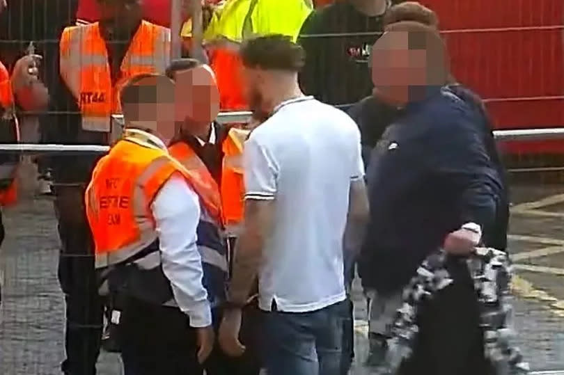 Kemp wearing an England top standing next to a group of stewards