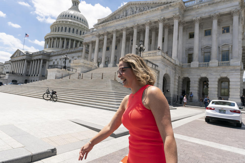 FILE - In this June 24, 2021, file photo, Sen. Kyrsten Sinema, D-Ariz., smiles as she returns to the Capitol after a meeting with President Joe Biden at the White House in Washington. More than her shock of purple hair or unpredictable votes Sinema is perhaps best known for doing the unthinkable in Washington: spending time on the Republican side of the aisle. Her years in Congress have been a whirlwind of political style and perplexing substance, an anti-war liberal-turned-deal-making centrist who now finds herself at the highest levels of power.(AP Photo/Alex Brandon)