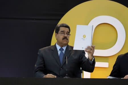 Venezuela's President Nicolas Maduro reads a document during the event launching the new Venezuelan cryptocurrency "Petro" in Caracas, Venezuela February 20, 2018. REUTERS/Marco Bello