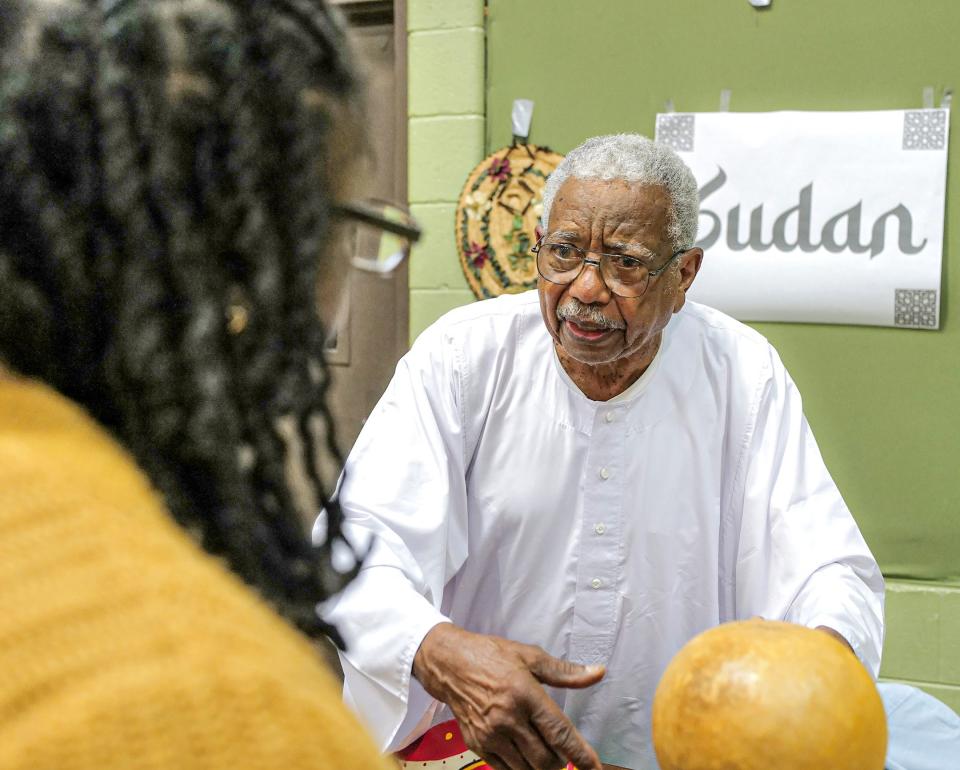 Michigan State professor Mohamed Khogali talks to Ebony Hicks of Lansing about his display of items used in Somalia at the Salaam Peace Festival Sunday, Oct. 2, 2022, at the Islamic Center of East Lansing.