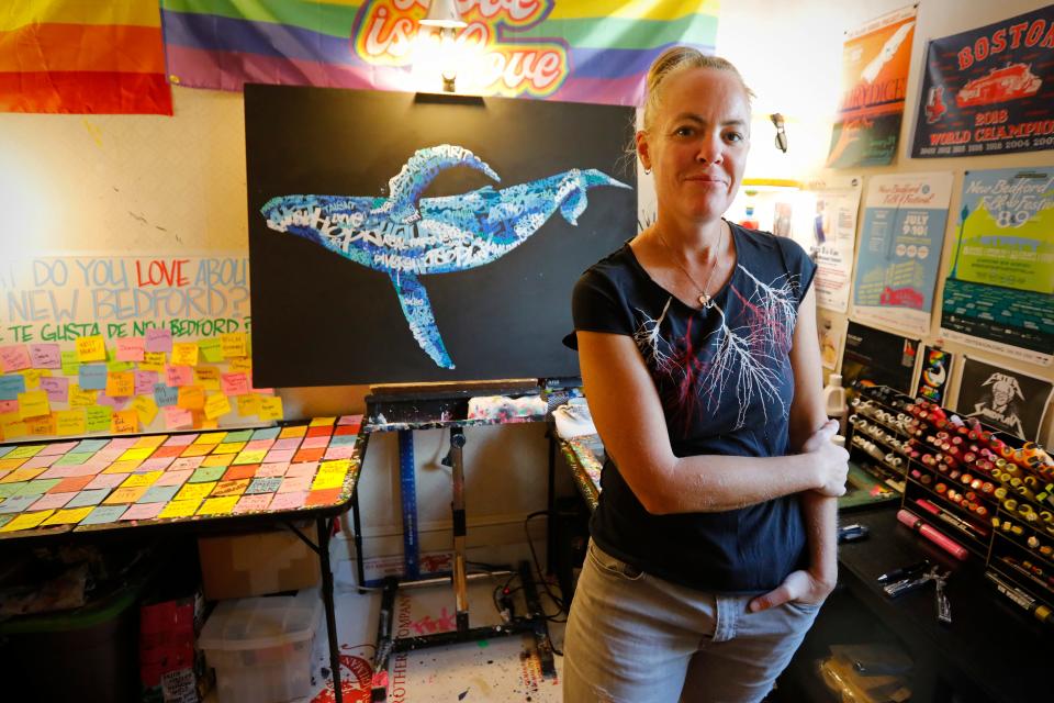 Mandy Fraser works on the "Love Letters to New Bedford" campaignn.  Behind her one of her Secret Whales art pieces painted using words which people submitted to her describing why they love the city.