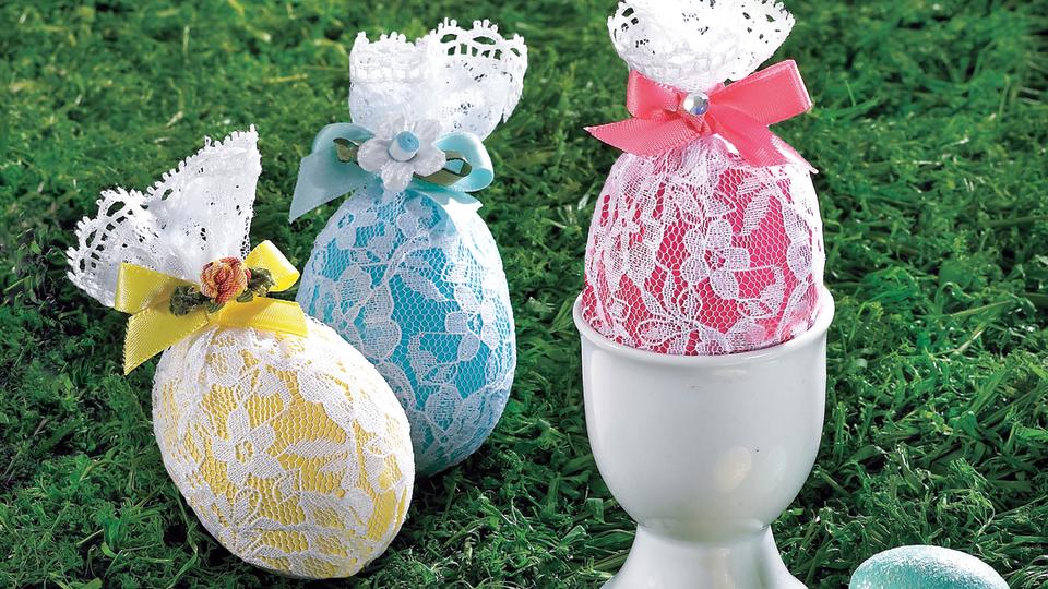 Cool Easter egg designs: Three colorful Easter eggs wrapped in lace and tied with ribbon