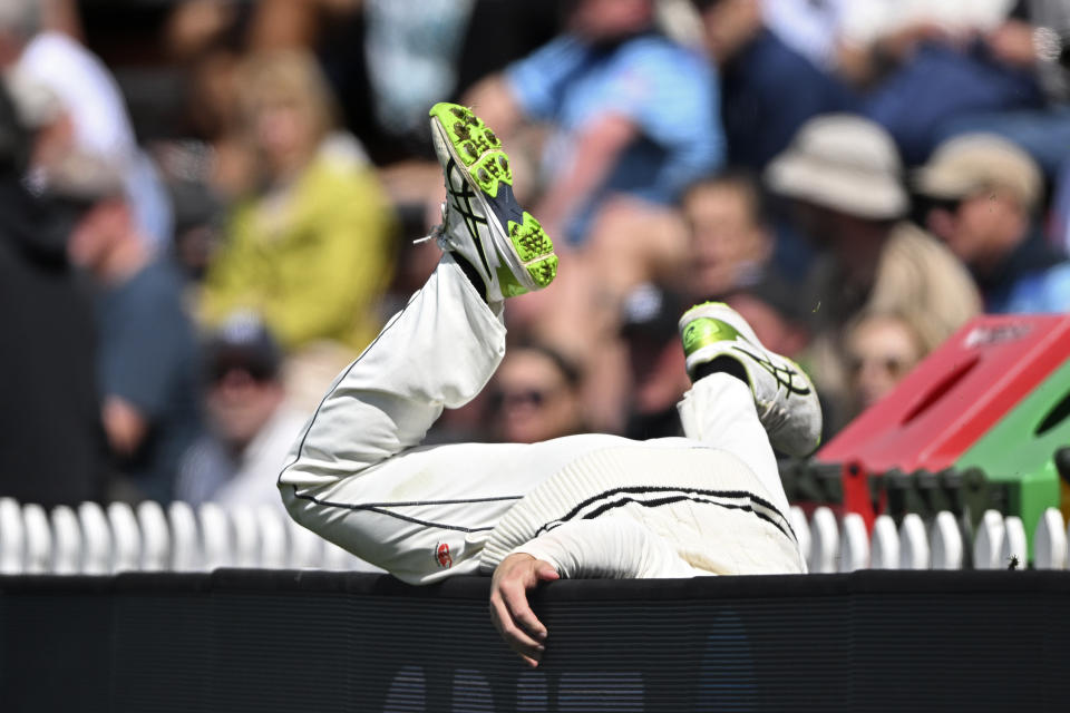 New Zealand's Kane Williamson falls over a boundary fence while fielding against England on day 5 of their cricket test match in Wellington, New Zealand, Tuesday, Feb 28, 2023. (Andrew Cornaga/Photosport via AP)