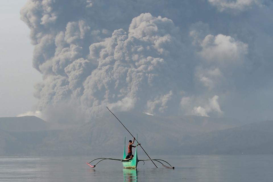 Man rowing boat in Philippines volcano. 