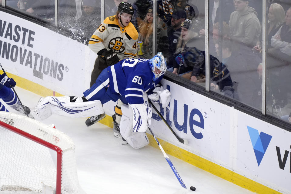 Toronto Maple Leafs goaltender Joseph Woll (60) and Boston Bruins left wing Danton Heinen (43) vie for control of the puck in the first period of an NHL hockey game, Thursday, March 7, 2024, in Boston. (AP Photo/Steven Senne)