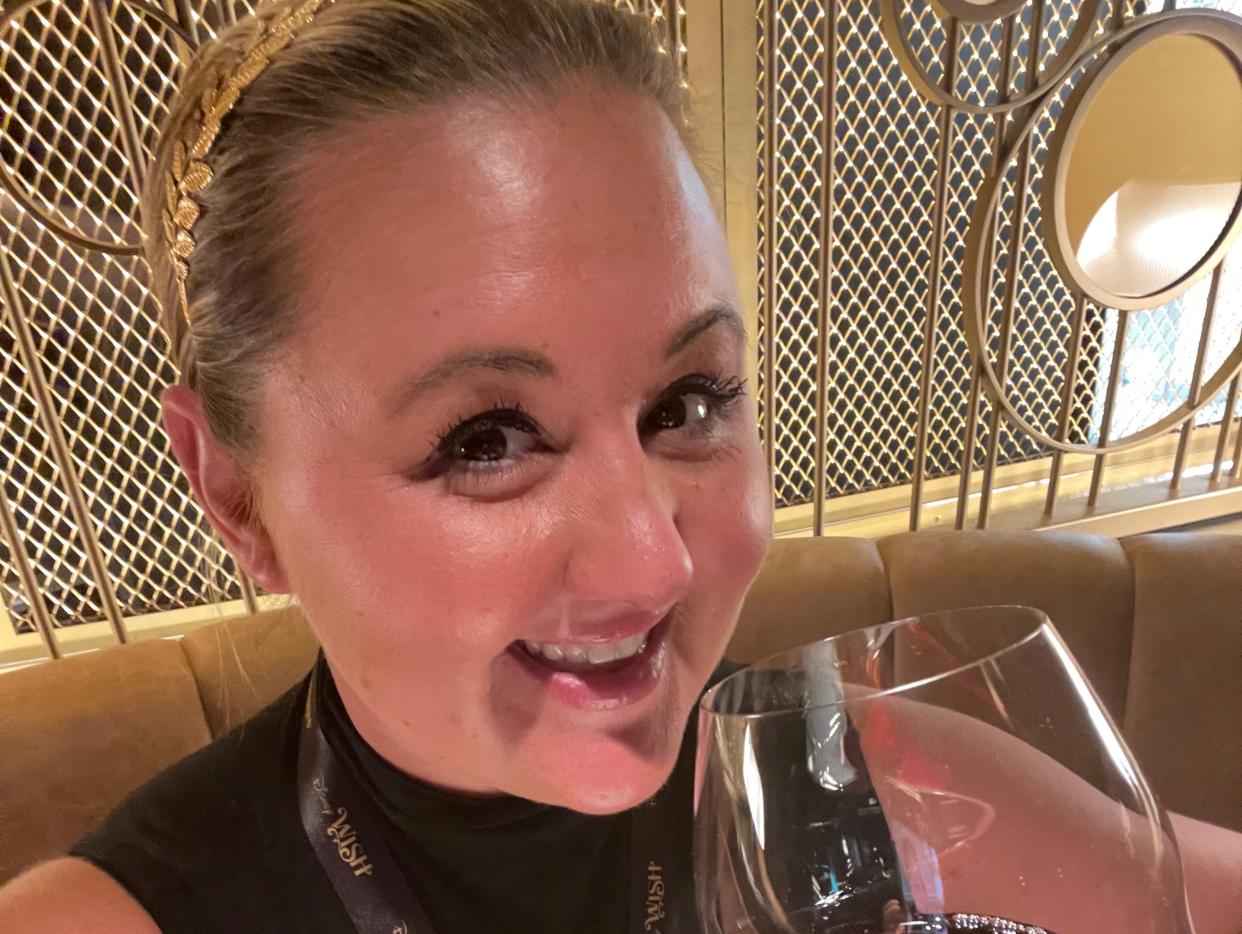 Carly Caramanna smiling with wine glass on disney wish