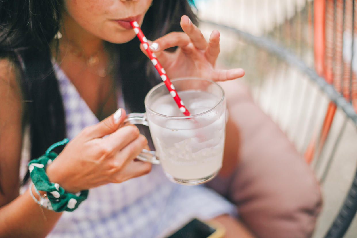 Close up of smiling woman having a drink outdoors