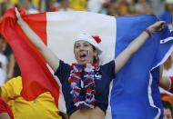 A fan of France holds their national flag as she waits for the 2014 World Cup quarter-finals soccer match against Germany at the Maracana stadium in Rio de Janeiro July 4, 2014. REUTERS/Darren Staples