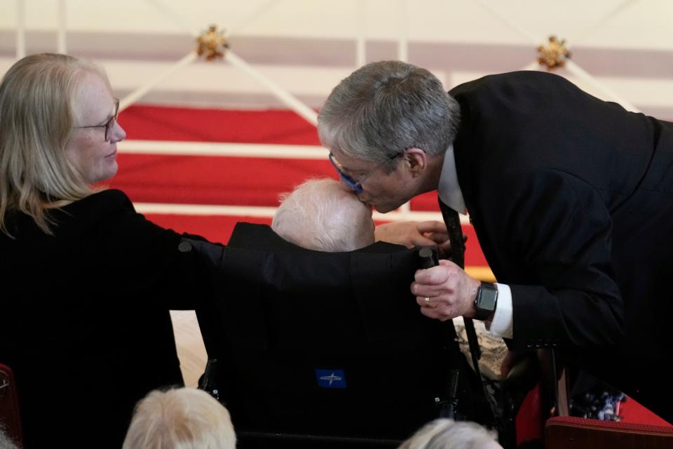 A photo of James "Chip" Carter kissing his father, former President Jimmy Carter, on the forehead.