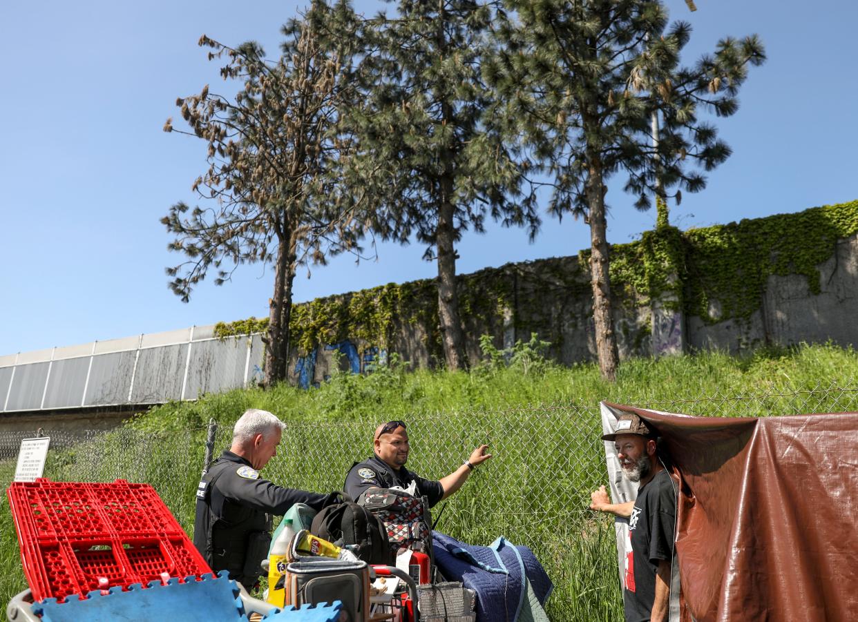 Officers Sean Bennett and Kevin Ramirez with Salem Police's Homeless Services Team check on people experiencing homelessness on Thursday, May 11, 2023 in Salem, Ore.