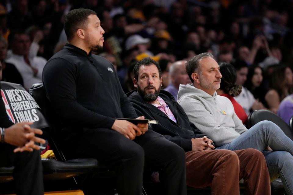 Actor Adam Sandler, center, watches the NBA's Western Conference Final game between the Los Angeles Lakers and the Denver Nuggets in 2023 in Los Angeles.