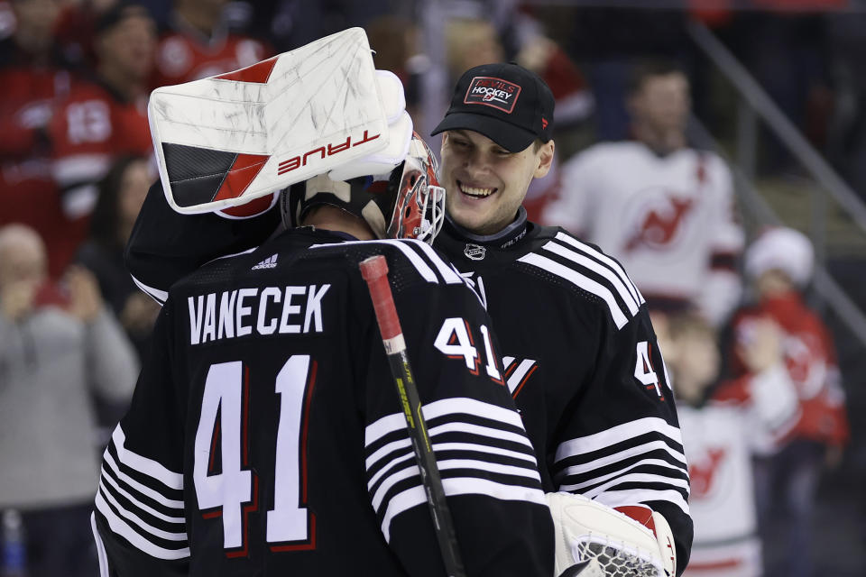 New Jersey Devils goaltender Akira Schmid, right, hugs teammate Vitek Vanecek (41) after defeating the Detroit Red Wings in an NHL hockey game Saturday, Dec. 23, 2023, in Newark, N.J. (AP Photo/Adam Hunger)