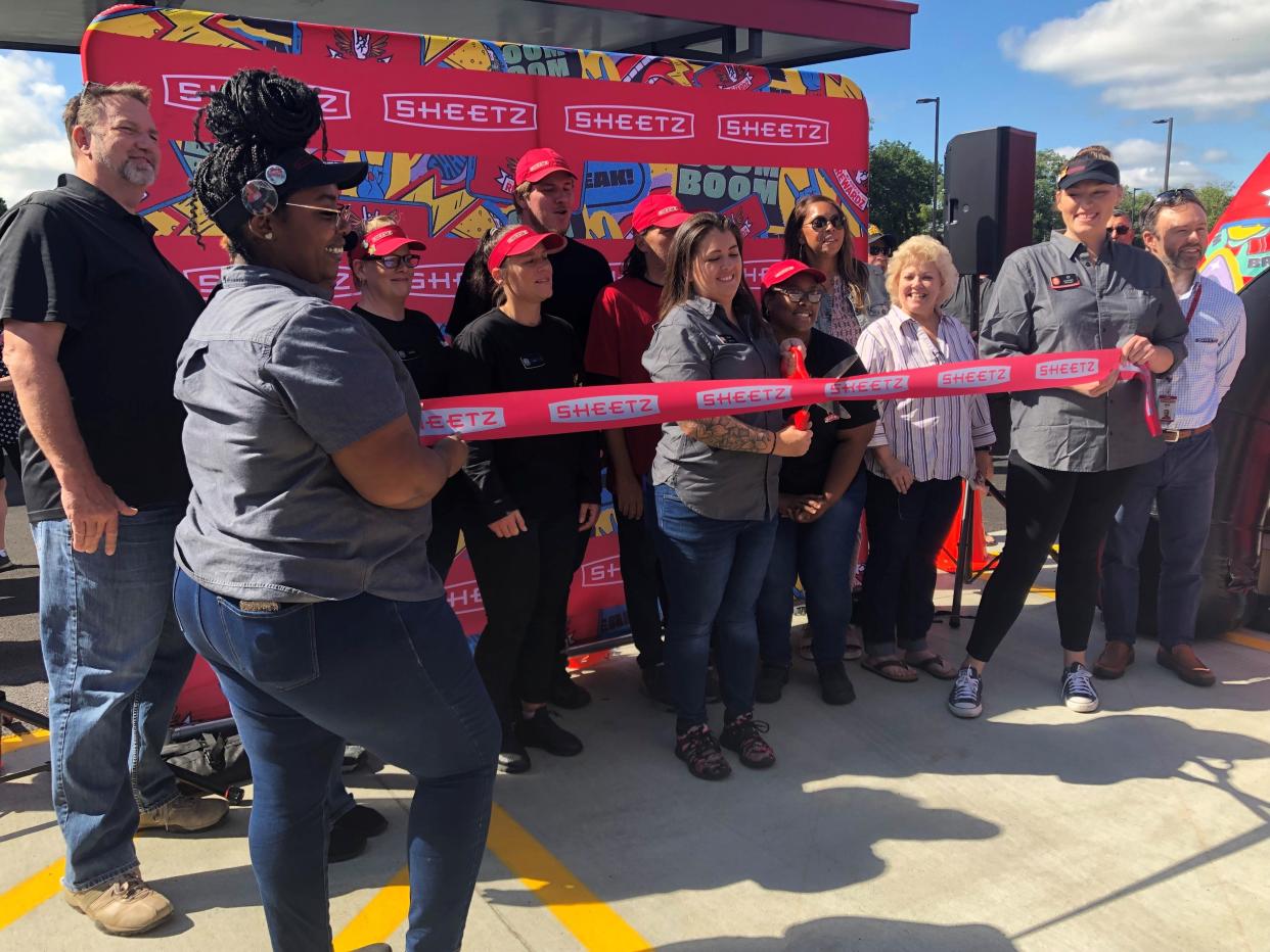Staci Reed, center, the manager for the new Etan Township Sheetz location, cuts the ribbon during a grand open celebration for store on Thursday, Aug. 31. The Etna store, located at the corner of U.S. 40 and Ohio 310, is the third Sheetz location in Licking County.