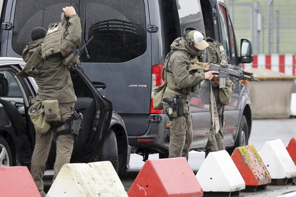 Heavily armed special police forces prepare for an operation at the airport, in Hamburg, Germany, Sunday, Nov. 5, 2023. An armed man is holding his four-year-old daughter at the airport. According to the police, the background to the attack is a custody dispute.(Bodo Marks/dpa via AP)