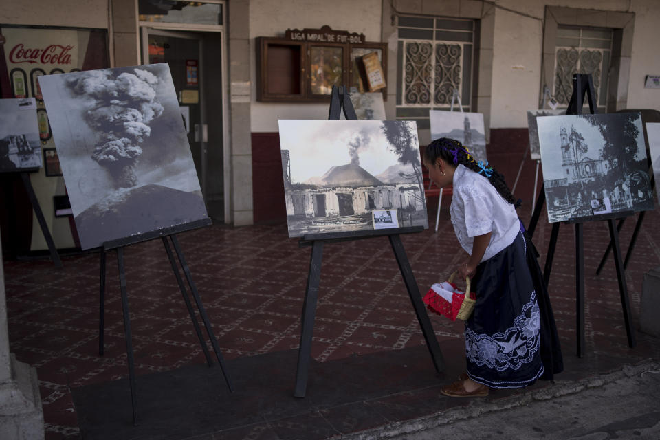 Una chica mira una exhibición sobre fotos históricas del volcán Paricutín en conmemoración de la erupción inicial que duró nueve años, en San Juan Nuevo Parangaricutiro, México, el lunes 20 de febrero de 2023. Un equipo de geólogos del Departamento de Interior de Estados Unidos y científicos mexicanos visitaron el lugar en 20 ocasiones durante los siguientes años y elaboraron un informe sobre los nueve años de erupción más de una década después. (AP Foto/Eduardo Verdugo)