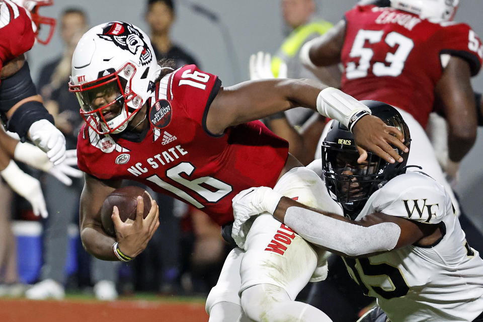 Wake Forest's Kendron Wayman (35) ties up North Carolina State quarterback MJ Morris (16) during the first half of an NCAA college football game in Raleigh, N.C., Saturday, Nov. 5, 2022. (AP Photo/Karl B DeBlaker)