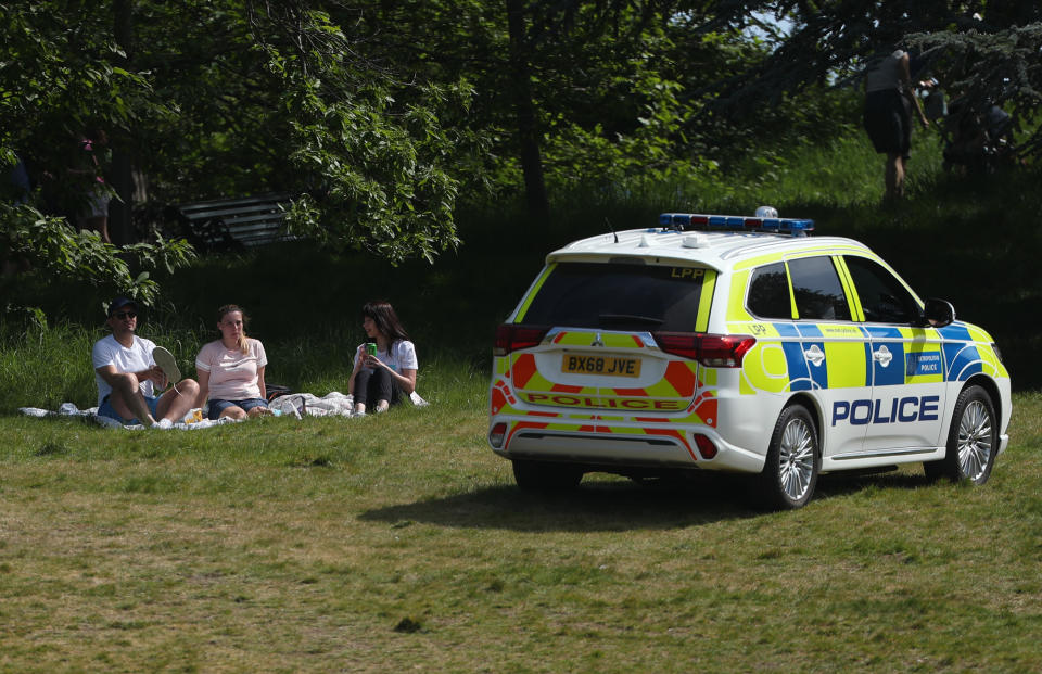 Police officers in a patrol car move sunbathers on in Greenwich Park, London, as the UK continues in lockdown to help curb the spread of the coronavirus.