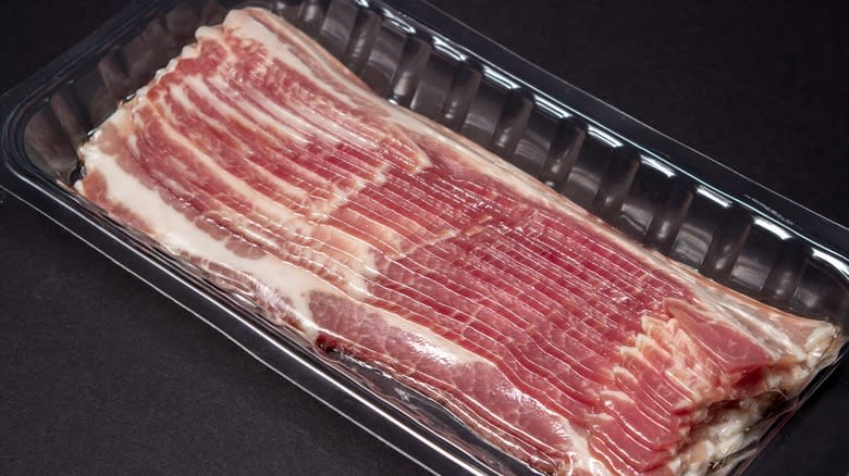 strips of uncooked bacon in black container