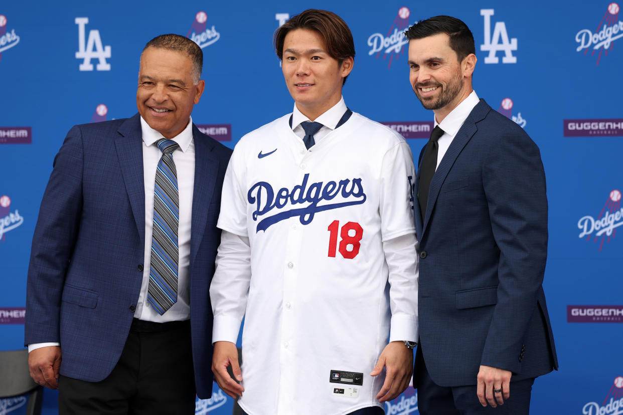 LOS ANGELES, CA - DECEMBER 27: Newly acquired Los Angeles Dodgers pitcher Yoshinobu Yamamoto (18) poses for a photo with manager Dave Roberts (left) and general manager Brandon Gomes (right) during an introductory press conference on December 27, 2023 at Dodger Stadium in Los Angeles, CA. (Photo by Kiyoshi Mio/Icon Sportswire via Getty Images)