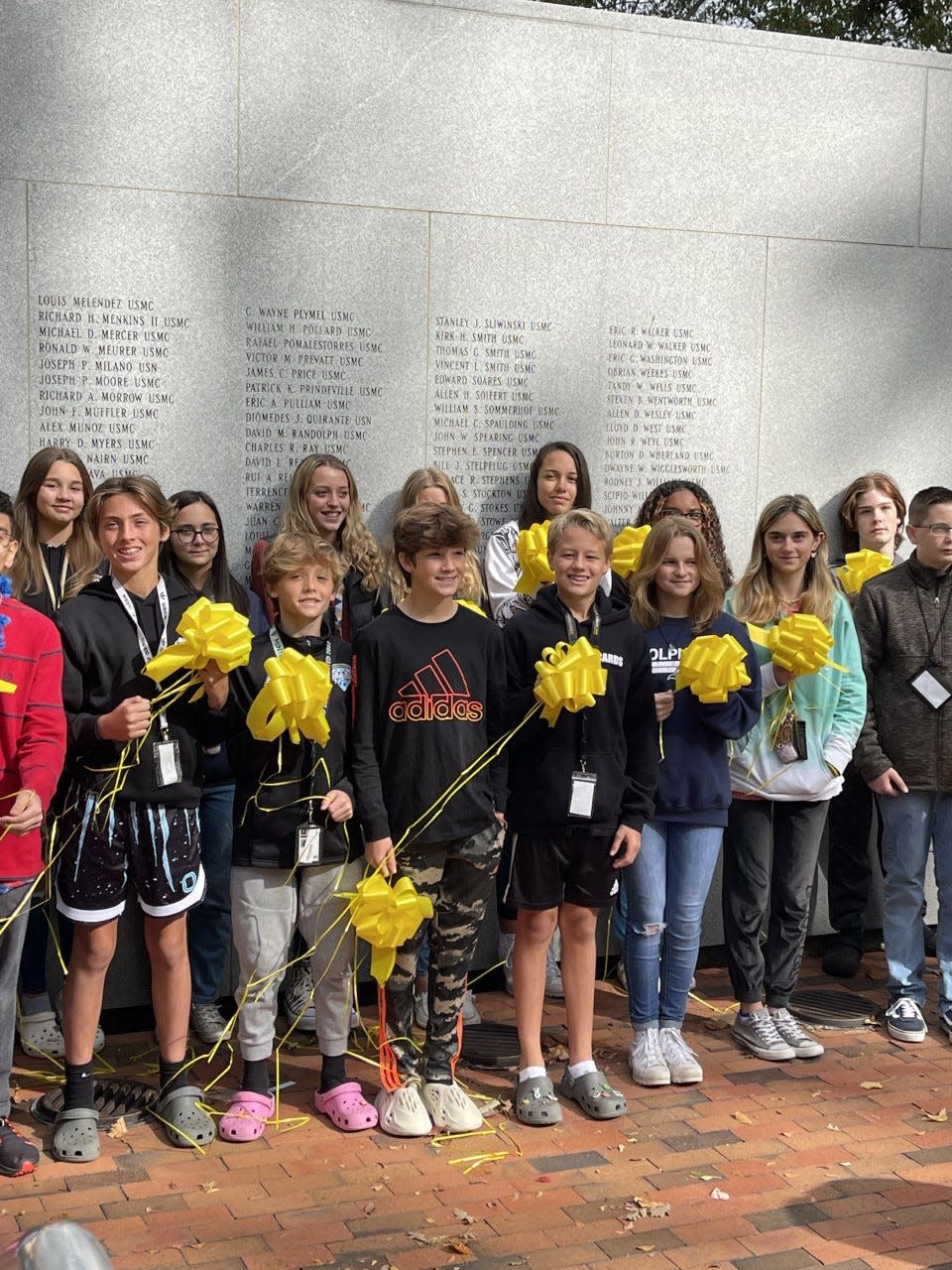 Northwoods Park Middle students and Beirut survivors smile as they hold their yellow ribbons.