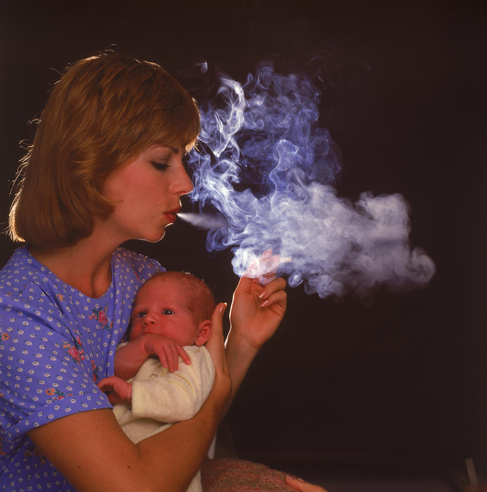 Smoking mother holding infant