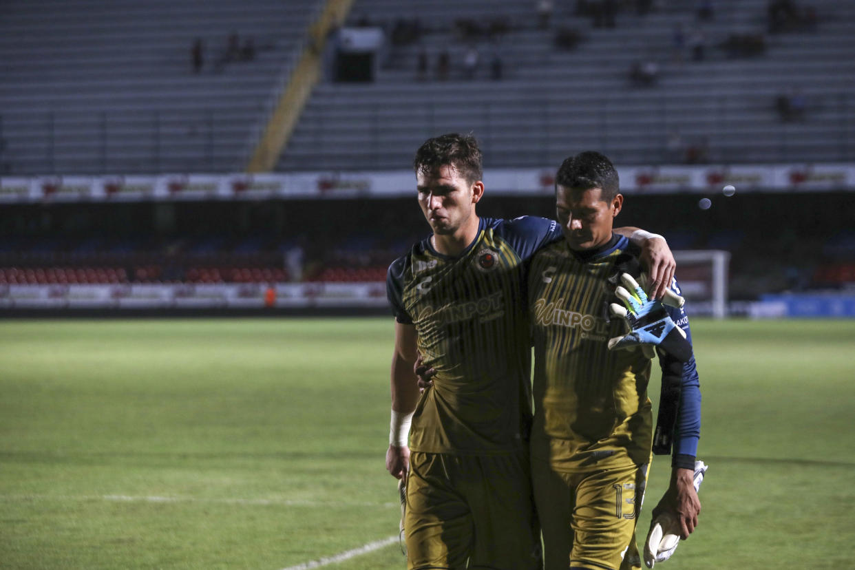 Veracruz players Sebastian Jurado, left, and Meliton Hernandez, leave the field after losing their Mexican soccer league match to Queretaro in Veracruz, Mexico, Tuesday, Aug. 27, 2019. The Tiburones Rojos from Veracruz set a world record Tuesday for a top-flight team with the most games in a row, 33, without a single win. (AP Photo/Felix Marquez)