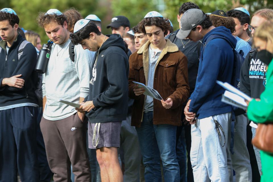 Students lower their heads as they pray together at the Israel vigil held in front of the university’s Engineering Mall, on Wednesday, October 11, 2023, in West Lafayette, Ind.