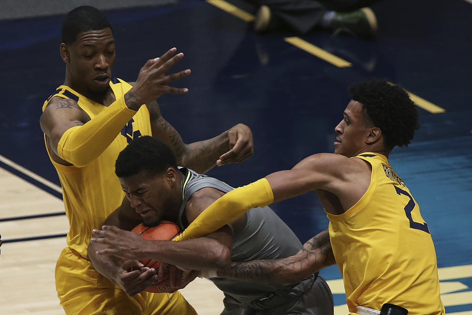 Baylor guard Jared Butler (12) is defended by West Virginia forwards Gabe Osabuohien (3) and Jalen Bridges (2) during the first half of an NCAA college basketball game Tuesday, March 2, 2021, in Morgantown, W.Va. (AP Photo/Kathleen Batten)