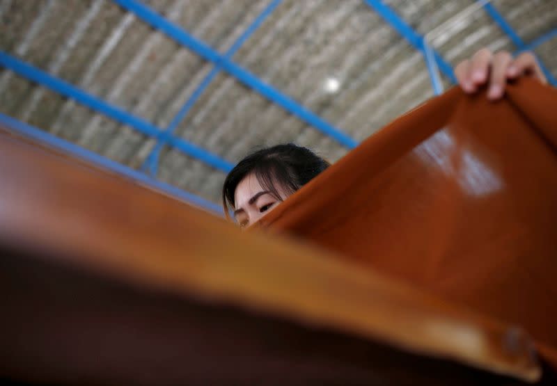 Una mujer cose una túnica hecha de botellas de plástico en un monasterio de Bangkok, Tailandia 6 de febrero de 2020