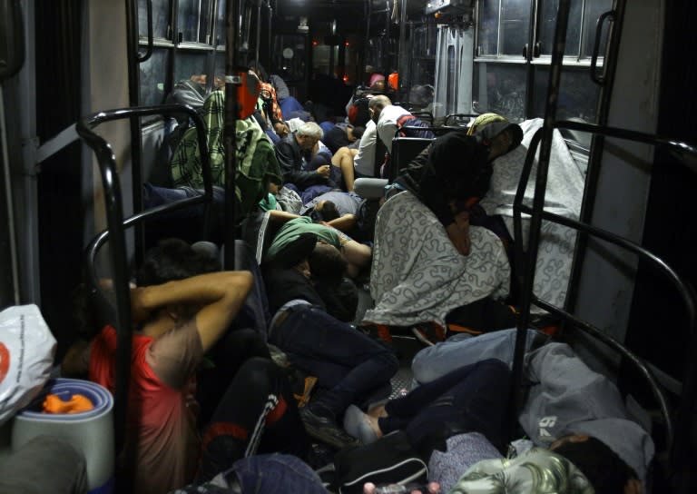 Migrants sleep on a bus as they are transported from Budapest to the Hungarian border village of Hegyeshalom, early on September 5, 2015