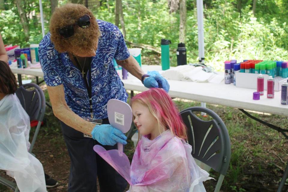 Volunteer Lynn French shows Charlotte Halvorsen, 5, her newly pink hair during the Enchanted Faire at the Overland Park Arboretum.