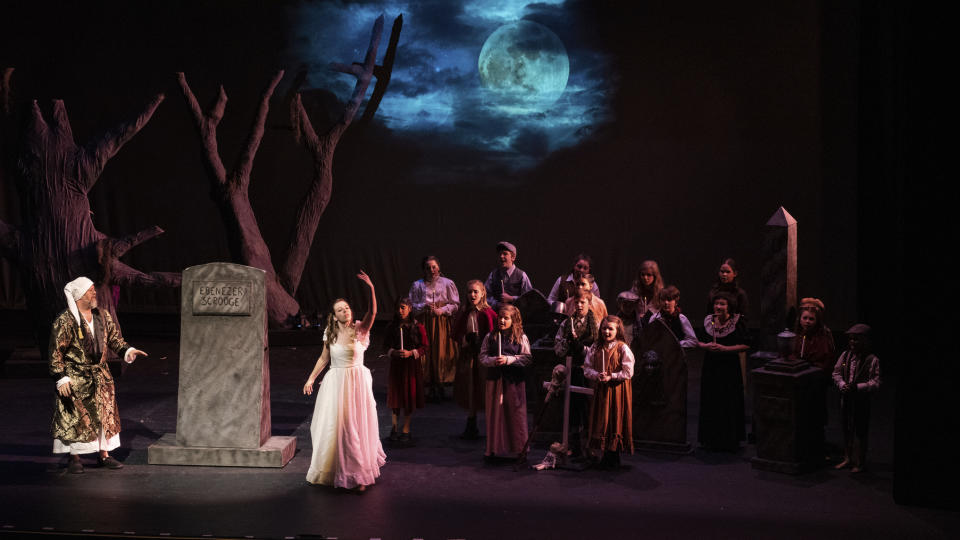 This undated photo provided by High Point Community Theatre in High Point, N.C., shows a scene from the 2017 production of "Ebenezer Scrooge." Jimmy Miller, shown here as Ebenezer Scrooge, left, begins to see the error of ways, as he sees the ghost of his beloved sister Fan, played by Kayla Miller. For many, community plays are a holiday tradition. (Brad McMillan/High Point Community Theatre via AP)