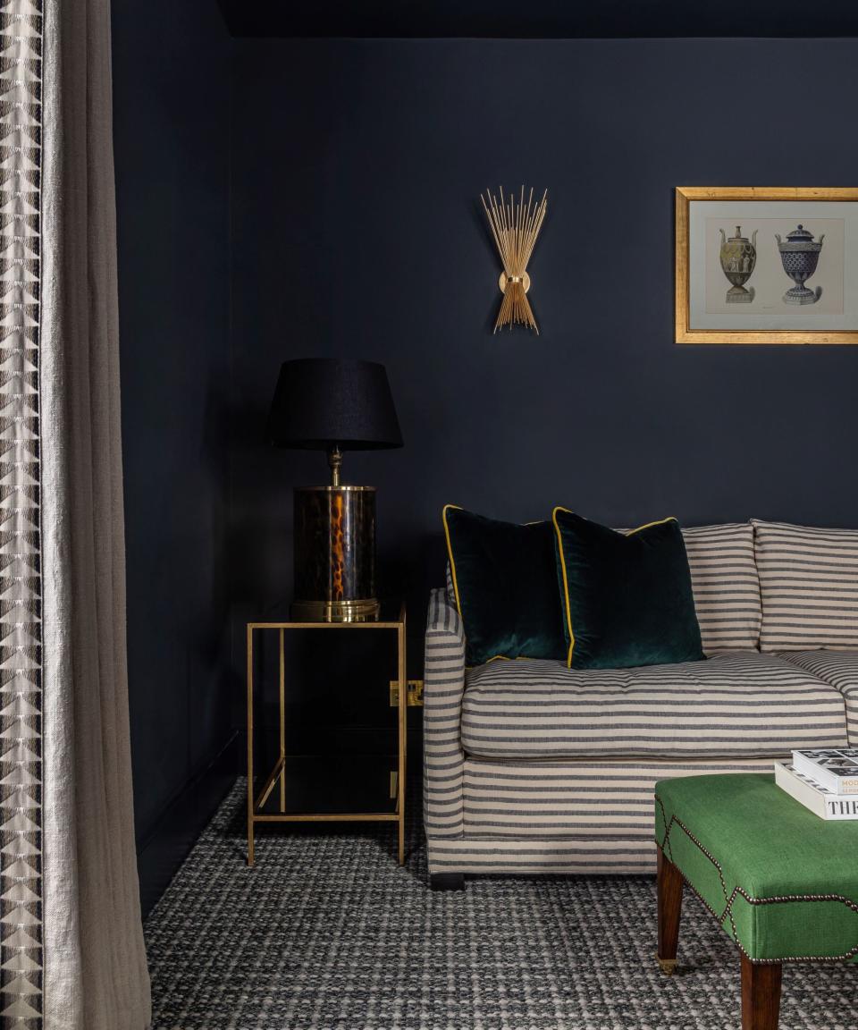 living room with dark walls and striped sofa