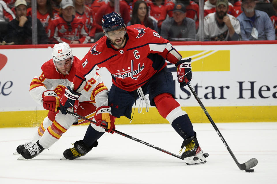 Washington Capitals left wing Alex Ovechkin (8) skates with the puck against Calgary Flames center Dillon Dube (29) during the second period of an NHL hockey game, Saturday, Oct. 23, 2021, in Washington. (AP Photo/Nick Wass)