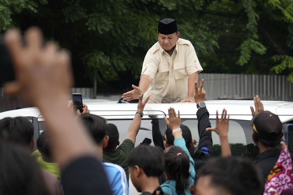 Indonesian Defense Minister and presidential frontrunner Prabowo Subianto greets supporters after visiting his father's grave in Jakarta, Indonesia Thursday, Feb. 15, 2024. The wealthy ex-general looks set to be the country's next president after unofficial tallies showed him taking a clear majority in the first round of voting. (AP Photo/Tatan Syuflana)