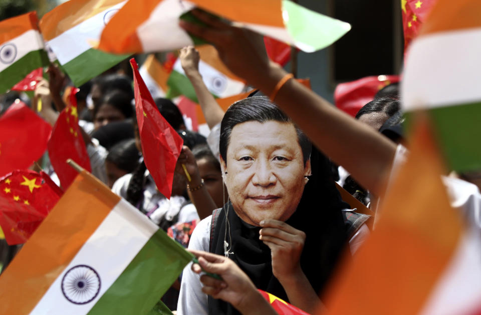 An Indian schoolgirl wears a face mask of Chinese President Xi Jinping to welcome him on the eve of his visit in Chennai, India, Thursday, Oct. 10, 2019. Chinese President Xi Jinping is coming to India to meet with Prime Minister Narendra Modi on Friday, just weeks after China supported Pakistan in raising the issue of India's recent actions in disputed Kashmir at the U.N. General Assembly meeting in New York. (AP Photo/R. Parthibhan)