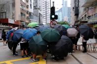 Anti-government protesters set up roadblocks under umbrellas during a march against Beijing's plans to impose national security legislation in Hong Kong