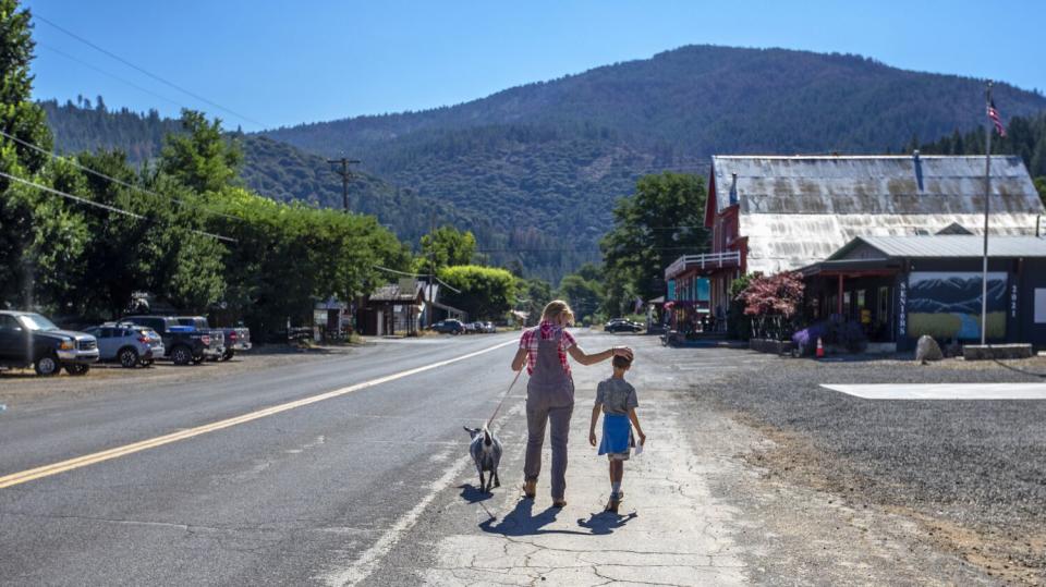 Kjessie Essue and her son, Hugo, walk with their Nigerian Dwarf dairy goat walk home