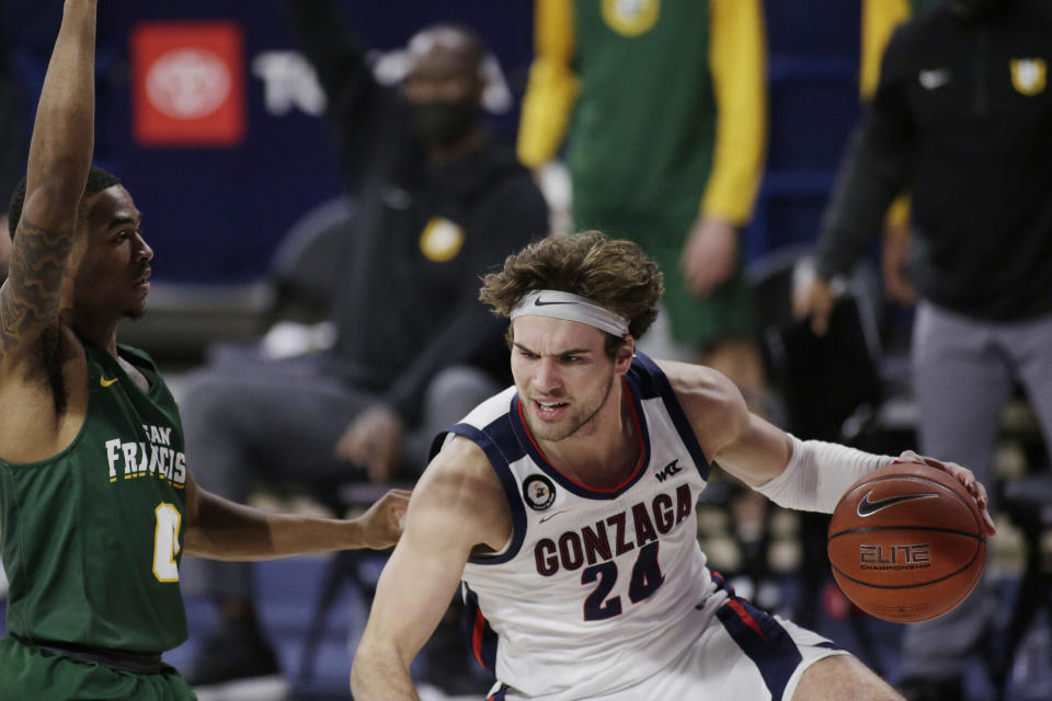 Gonzaga forward Corey Kispert, right, dribbles while pressured by San Francisco guard Khalil Shabazz during the first half of an NCAA college basketball game in Spokane, Wash., Saturday, Jan. 2, 2021. (AP Photo/Young Kwak)