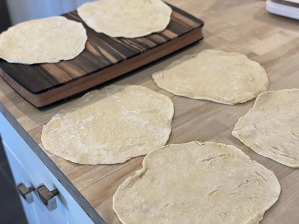 six fresh tortillas on a kitchen counter