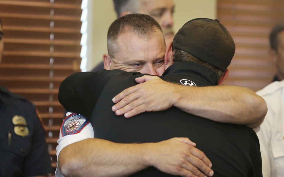 Draper Battalion Chief Bart Vawdrey hugs a fellow firefighter during a press conference in Draper, Utah, on Tuesday, Aug. 14, 2018. Draper Battalion Chief Matthew Burchett was killed on Monday night while fighting the largest blaze in California history, the Mendocino Complex fire north of San Francisco. (Jeffrey D. Allred/The Deseret News via AP)