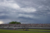 Colton Herta leads as storm clouds gather on his way to winning the IndyCar Grand Prix auto race at Indianapolis Motor Speedway in Indianapolis, Saturday, May 14, 2022. (AP Photo/Michael Conroy)