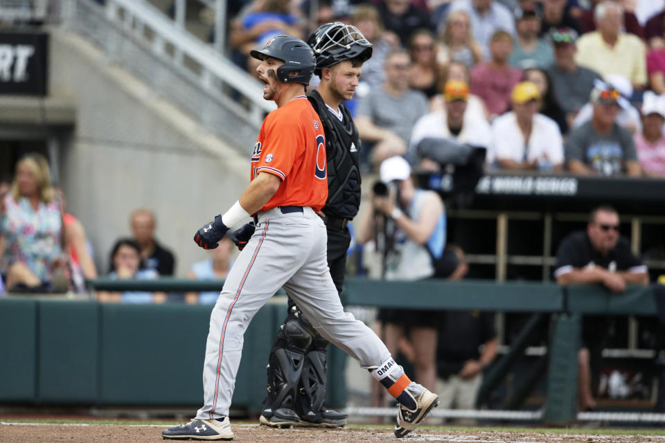 Auburn's Edouard Julien, center left, celebrates his two-run home run in front of Mississippi State catcher Dustin Skelton, center right, in the second inning of an NCAA College World Series baseball game in Omaha, Neb., Sunday, June 16, 2019. Rankin Woley also scored on the play. (AP Photo/Nati Harnik)