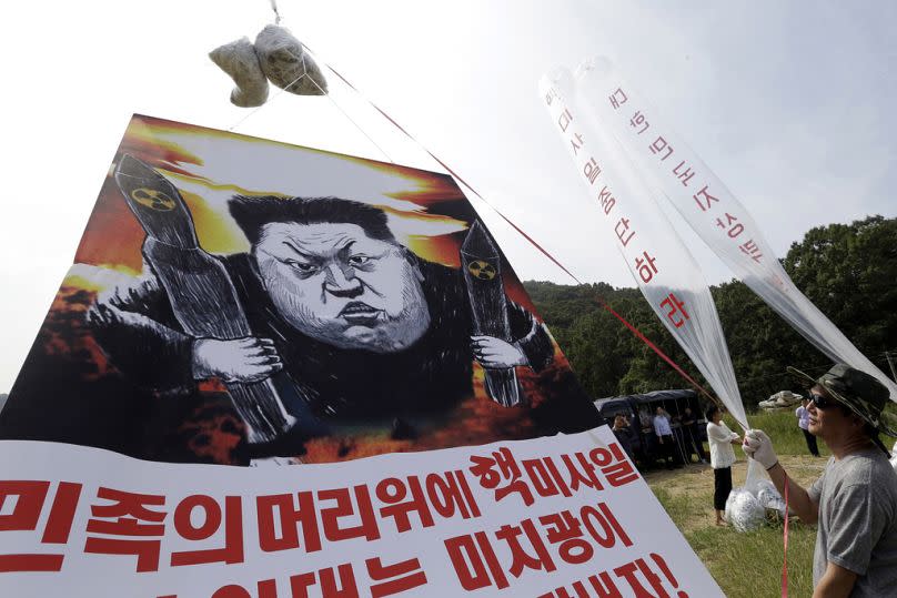 North Korean defectors prepare to release balloons carrying leaflets and a banner denouncing North Korean leader Kim Jong-un.