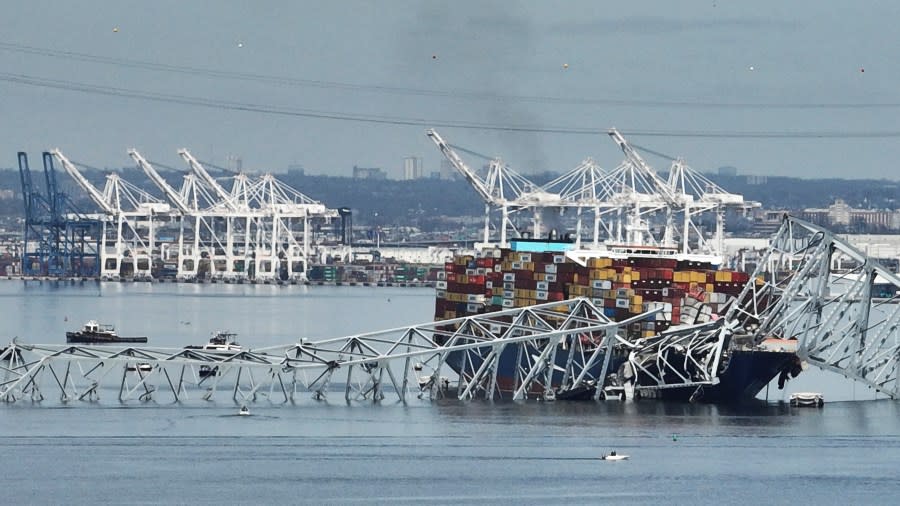 A cargo ship is stuck under the part of the structure of the Francis Scott Key Bridge after the ship hit the bridge Tuesday, March 26, 2024, in Baltimore, Md. (AP Photo/Steve Helber)