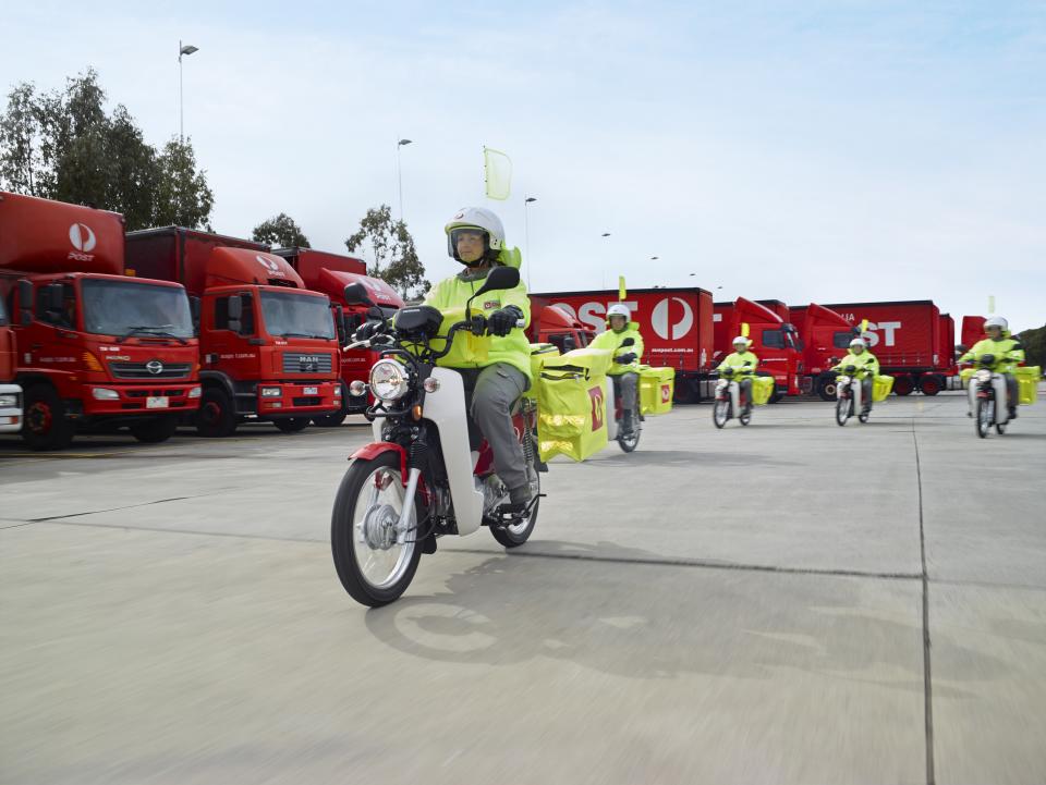 Picture of Australia Post delivery trucks and posties on motorbikes.