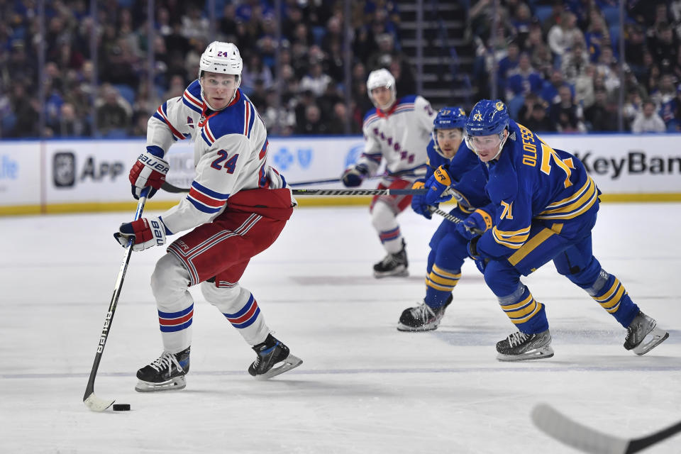 New York Rangers right wing Kaapo Kakko (24) looks to pass while pressured by Buffalo Sabres left wing Victor Olofsson (71) and center Tyson Jost during the first period of an NHL hockey game in Buffalo, N.Y., Friday, March 31, 2023. (AP Photo/Adrian Kraus)