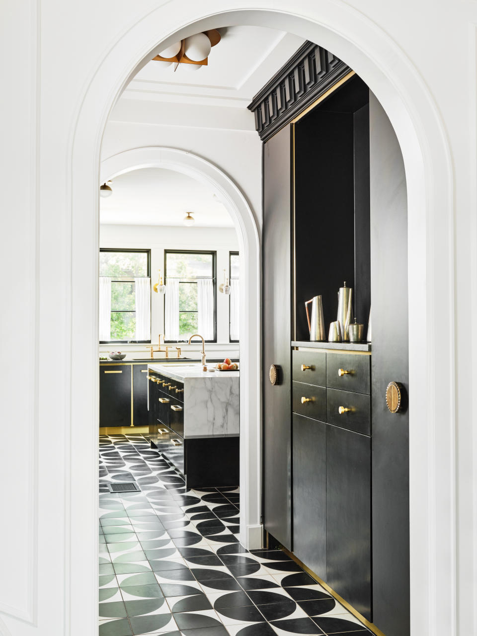 A kitchen with black and white flooring and a coffee counter