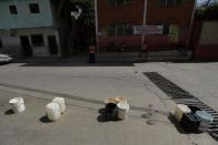 Plastic containers are placed with social distancing measures near a water source in in the low-income neighbourhood of Petare amid the coronavirus disease (COVID-19) outbreak in Caracas