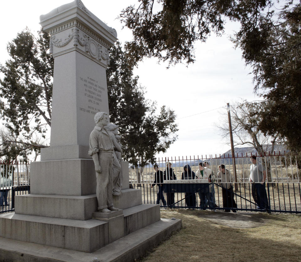 FILE - This Feb. 28, 2008 file photo shows visitors at the monument to those killed in the Ludlow Massacre at the site near Ludlow, Colo. Sunday, April 20, 2014 marks the 100th anniversary of the Ludlow Massacre where two women and 11 children were killed in a fire during a battle between striking coal miners and Colorado National Guard. (AP Photo/David Zalubowski, File)